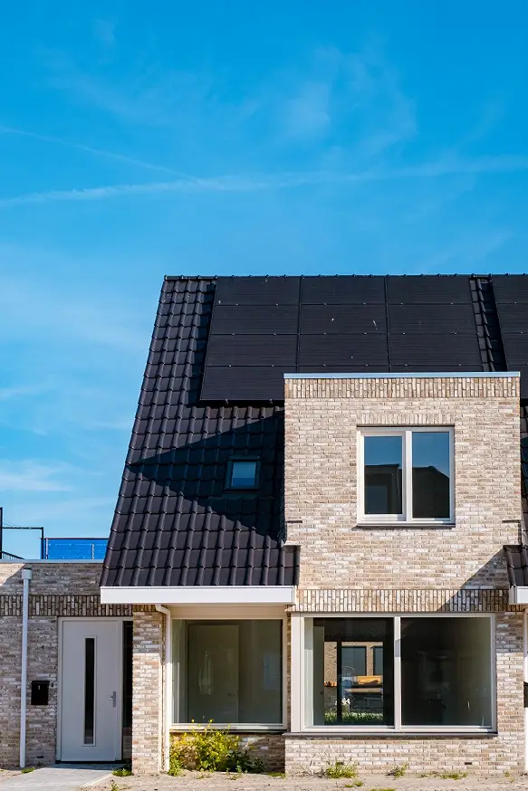 A brick home with solar panels on a clear day
